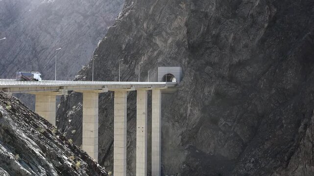 Artvin mountain highway bridge spans rocky valley beside tunnel entrance and steep gorge.