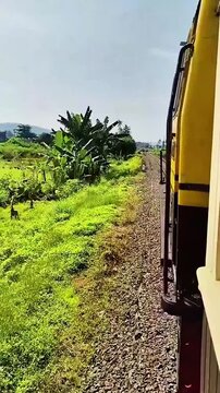 Salatiga, Central Java, Indonesia - May 29 2025: 1080p 60fps travel video heading to Rawa Pening, featuring lush green rice fields captured from a moving train. High quality.