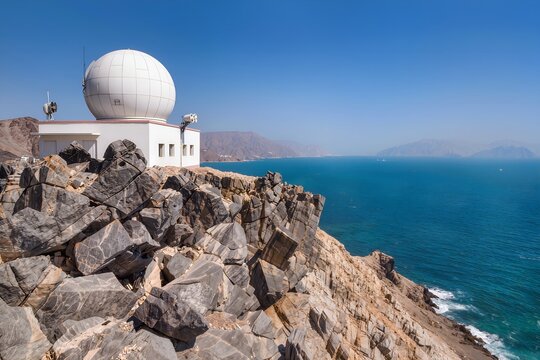 Modern White Coastal Radar Station Dome on Rocky Cliff Overlooking Strait of Hormuz Waters