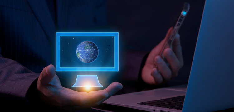 Businessman holding laptop computer while supporting world globe floating inside glowing monitor frame overlay display. Worldwide network connection and international internet server concept.