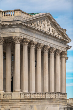 Columns marble repetition symmetry texture. Columns Tall vertical architectural design. Columns decorative capitals ornament Sculpture. Columns classical Roman exterior.