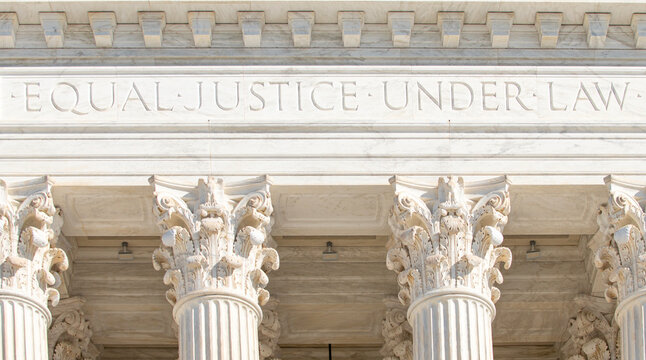 Equal Justice Under Law inscription on United States Supreme Court building. Marble columns of Supreme Court in Washington DC close up. Judicial branch symbol with neoclassical courthouse facade.