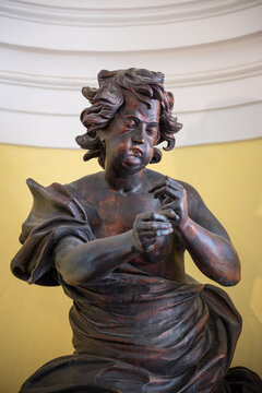 Portrait with the expression of a wooden ebony angel statue.