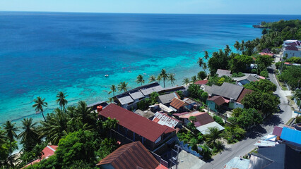 Naklejka premium Aerial View of Coastal Houses, White Beach, and Vibrant Blue Waters in Sabang, Aceh, Indonesia