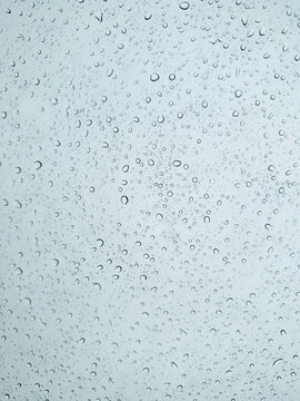 Raindrops on Glass with Light Blue Background
