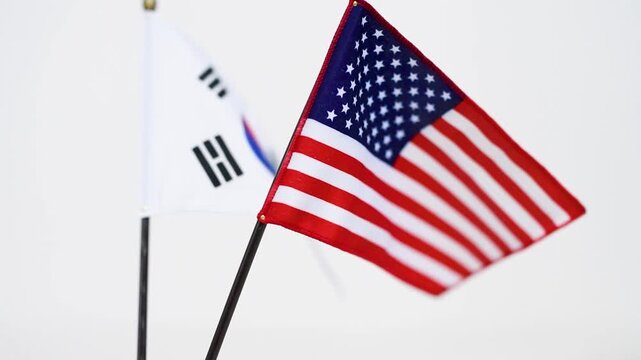 Two national flags waving together on table stand, international relations and diplomacy concept
