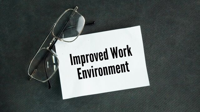 Glasses and paper with the words Improved work environment. a safer, more supportive, and better-organized workplace that boosts employee happiness, health, and productivity.