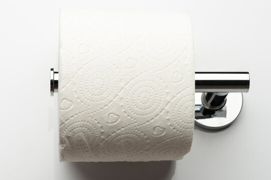 Paper towel roll placed on a chrome holder in a bathroom setting