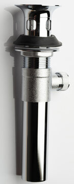 Metal sink drain assembly placed against a plain background