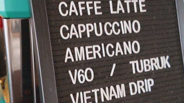 Close up shot of a coffee shop menu board displaying various types of coffee drinks.