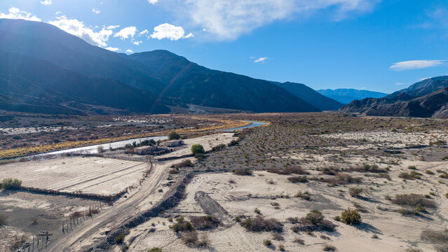 Aerial view of Ruinas de Planta de Sulfato de Aluminio situated in the arid landscape near a river with mountains in the background in Calingasta, San Juan, Argentina.