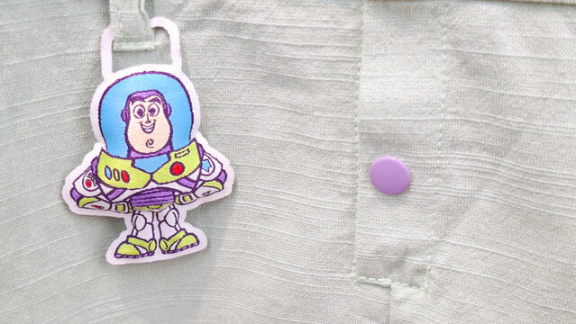 Detailed view of Buzz Lightyear embroidered character tag attached to textured fabric shirt on August 7, 2026 in Bangkok,  Thailand