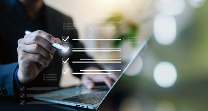 Business professional using a laptop with digital checklist and check marks, illustrating task management, workflow, project planning, productivity, compliance, and successful task completion.