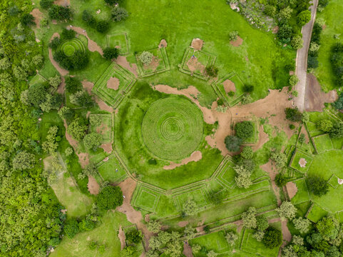 Aerial view of the circular pyramids and concentric terraces of the Guachimontones archaeological site surrounded by lush green grass and trees in Guachimontones, Jalisco, Mexico.