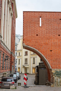 Riga, Latvia - 21 November 2019: Historic brick arch and cobblestone street. Swedish Gate in Riga Old Town