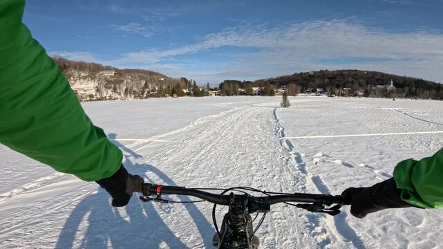 Fat Biking Across a Frozen Lake in Winter Wonderland - Scenic Adventure Cycling Experience. Exploring Frozen Lake Trails on a Fat Bike - Thrilling Winter Ride in Snowy Landscape
