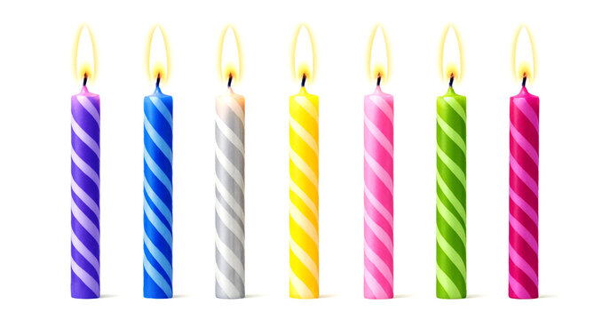 Brightly colored birthday candles with flames lit in a row showing festive celebration vibes