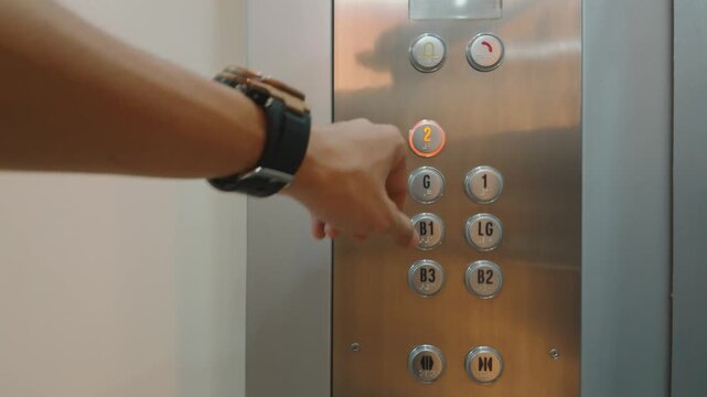Close up of a person pressing a button in an elevator.