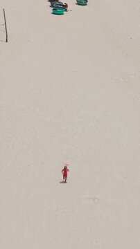 Vertical Aerial View Tracking Woman Running on Sandy Beach in Da Nang Vietnam