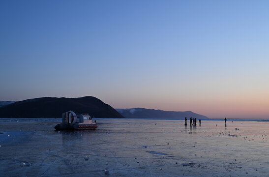 Tourists greet the winter dawn on Lake Baikal. Olkhon Gate Strait