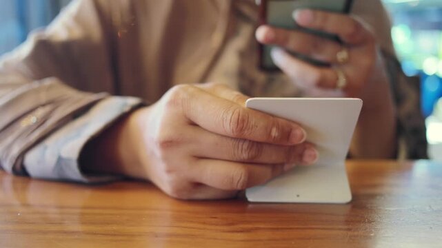 young woman holding smart phone to scan the QR code to the cafe menu 