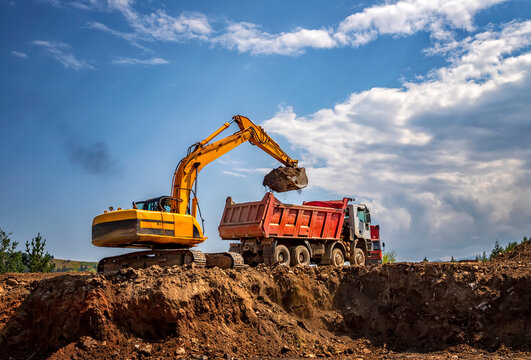Excavator Loading Soil into Dump Truck at Construction Site