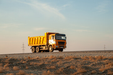 Orange Dump Truck Transporting Materials at Construction Site © William