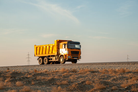 Orange Dump Truck Transporting Materials at Construction Site