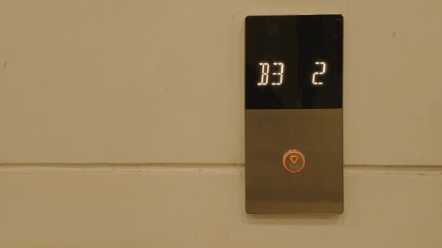 Modern elevator floor indicator panel with digital display showing floor numbers on a wall.