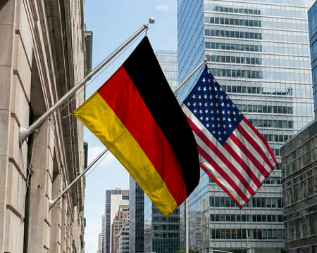 Germany and United States crossed national flags waving against a blue sky, representing bilateral relations and diplomacy.