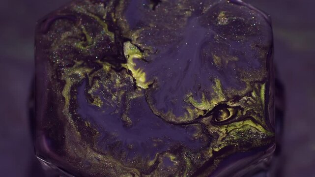 Spatter ink. Paint rhombus. Defocused yellow purple neon color glitter rock geometric water sparkling fluid floating on abstract background.