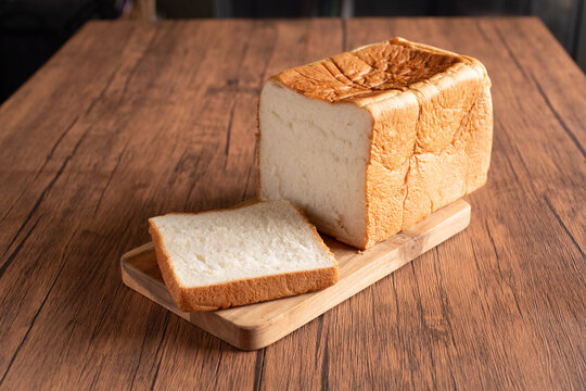日本の食パン（shokupan）とスライスした一枚を木製カッティングボードに置いたナチュラルな写真