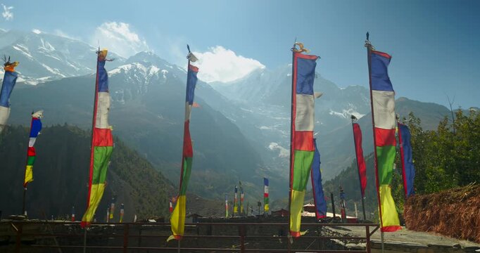 Annapurna Circuit, Manang, Nepal,Colorful Buddhist prayer flags fluttering against high Himalayan mountain peaks in the background
