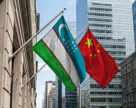 Uzbekistan and China crossed national flags waving against a blue sky, representing bilateral relations and diplomacy. 3D illustration.