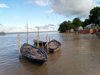 Traditional Wooden Boats on Padma River and Tropical Riverside Village at Dhalar Mor,Tepakhola, Faridpur © Mohibulk