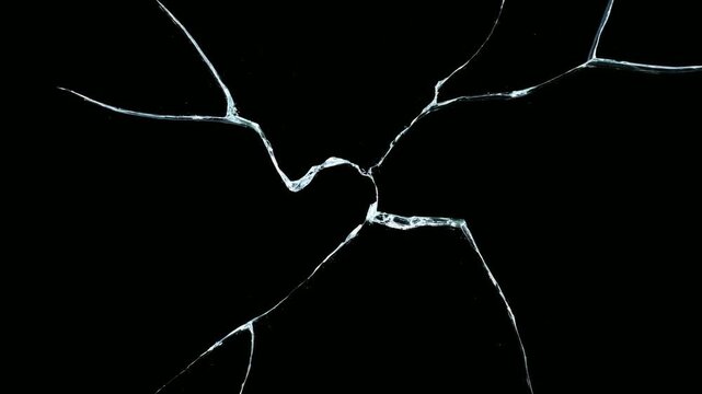Cracked glass shards spreading across black background, abstract background animation, seamless loop