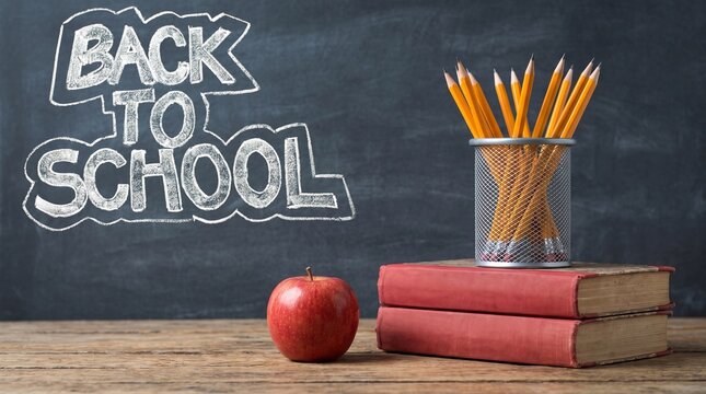 Back to School Chalk Text on Blackboard with Red Apple Pencils and Books on Vintage Wooden Desk