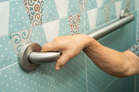 Asian elderly woman patient use toilet bathroom handle security in nursing hospital, healthy strong medical.