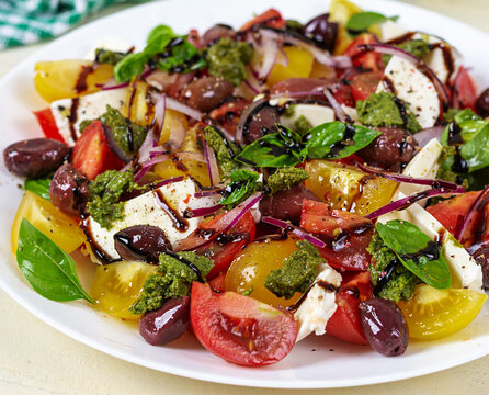 Colorful Greek Salad with Tomatoes, Olives and Pesto Sauce