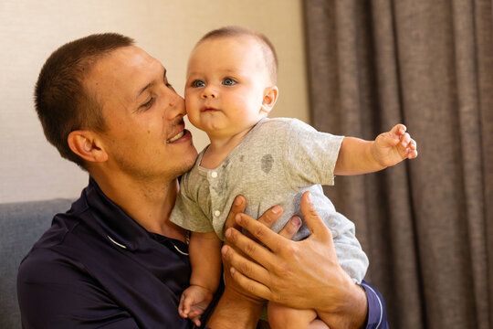 Father Holding Baby Son Close During Family Bonding