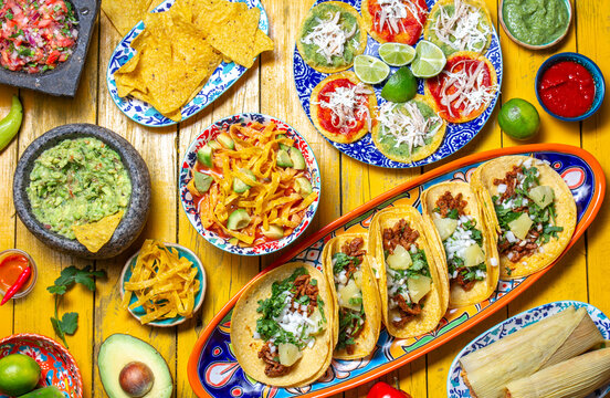 Festive spread of traditional Mexican dishes featuring taco varieties, chalupas, and vibrant sides perfect for celebration days