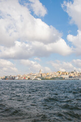Istanbul harbor view with passenger ferry, sparkling water and historic skyline topped by Galata Tower. Ideal for travel, cityscape and maritime transport themes. © Dasha Lapshina