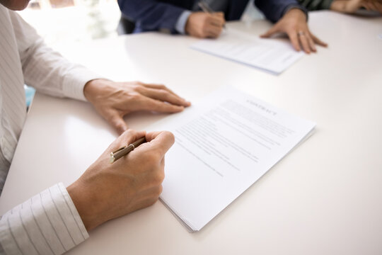 Cropped close up hands of male business representatives or managers validating contract with written signatures confirming enterprise deal authorizing service documents after professional discussion
