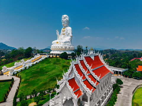 Landmark of Chiang Rai, White Wat Huay Pla Kang Goddess of Mercy, Aerial view temple complex under blue sky in Thailand.
