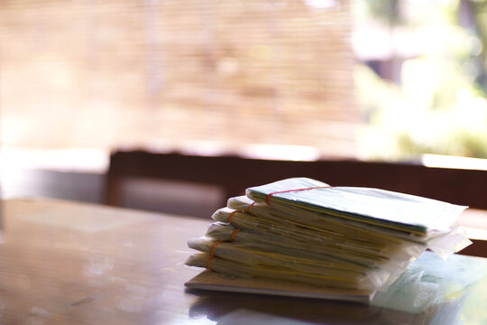 Stack of plastic wrapped savings books sitting on table in soft natural light