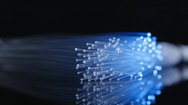 Close-Up Macro Of Glowing Fiber Optic Strands Emitting Blue Light Against Dark Background For Technology And Communication