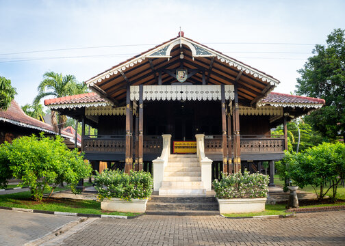 Traditional Bengkulu commoner's house with a raised wooden structure, distinctive roof, front veranda, stairs, and ornamental details at TMII.
