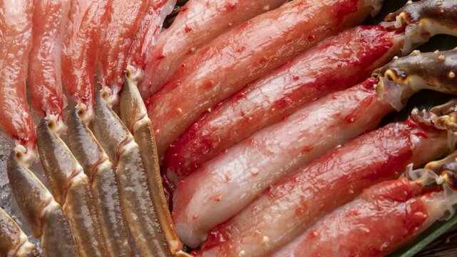 Raw snow crab leg meat portions lined up in a row, camera zooms in and pans across the fibers
