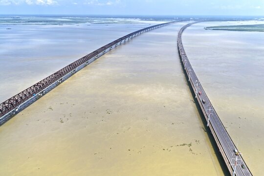 Aerial view of Jamuna Bridge spanning the Jamuna River with its long truss structure and highway, surrounded by vast calm waters in Tangail District, Dhaka Division, Bangladesh.
