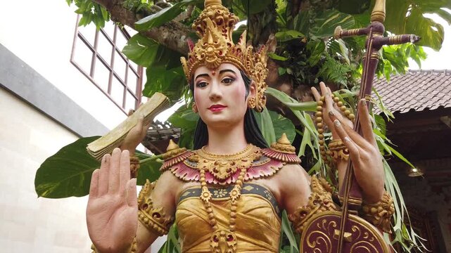 Dewi Saraswati Statue with Rebab Musical instrument Bali Indonesia Ubud, Goddess of Knowledge, Ground Level Close Up View